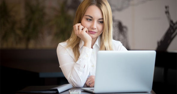 Mujer pensando frente a computadora